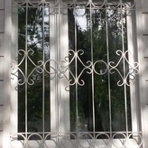 белая металлическая сварная решетка с ромбическими узорами на окно